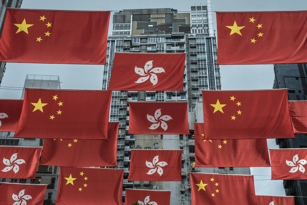 悬挂在一条购物街上的中国国旗和香港特别行政区（香港的正式名称）区旗，摄于2022年。