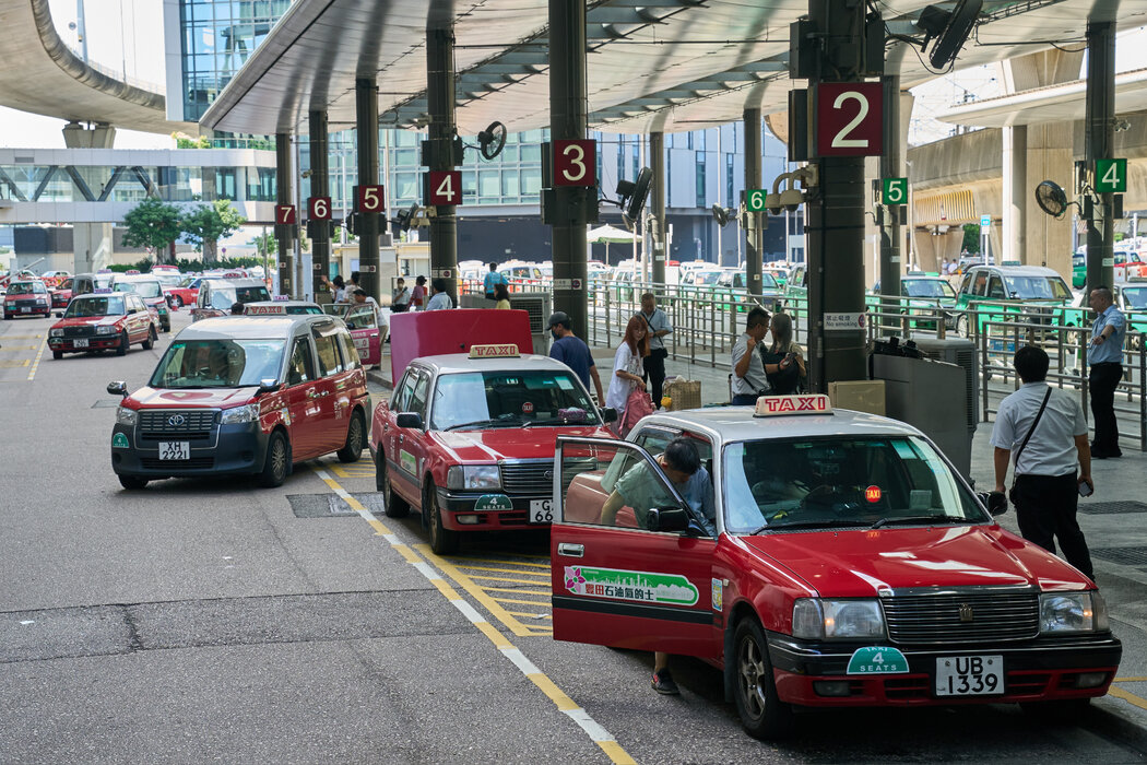 出租车在香港国际机场接客，摄于去年夏天。机场工作人员经常需要在出租车站提醒游客，许多的士只接受现金。