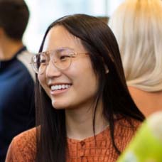 person smiling clear aviator glasses orange shirt