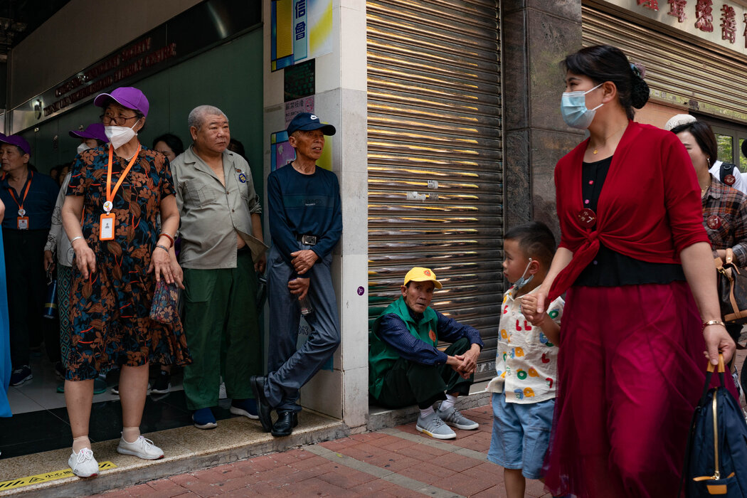 游客在土瓜湾一家餐馆外等候巴士。花钱不多的中国内地游客激增,引发了当地居民抱怨。