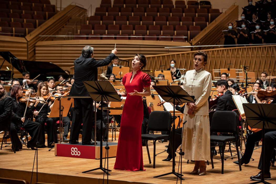 余隆指挥上海交响乐团排练《上海!上海!》,这部清唱剧讲述了犹太难民逃离纳粹德国到上海避难的故事,女高音张玫瑰(左)和女中音朱慧苓(右)在剧中扮演角色。