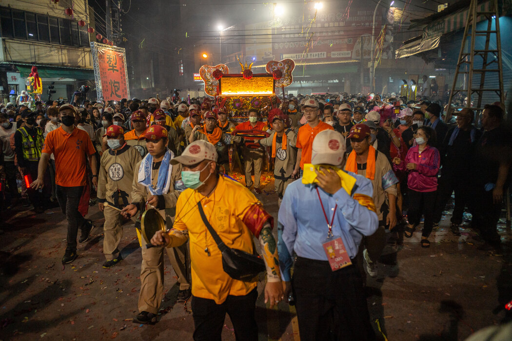 抬着妈祖穿过人群。近年来,许多台湾年轻人参加了进香活动。