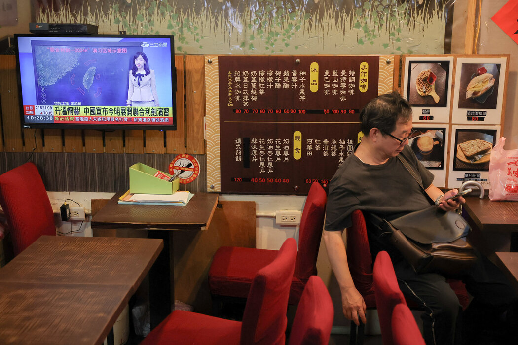 周四,台湾媒体上关于此次军演的新闻播报画面。台湾国防部表示,演习是“不理性挑衅”,破坏“区域和平稳定”。