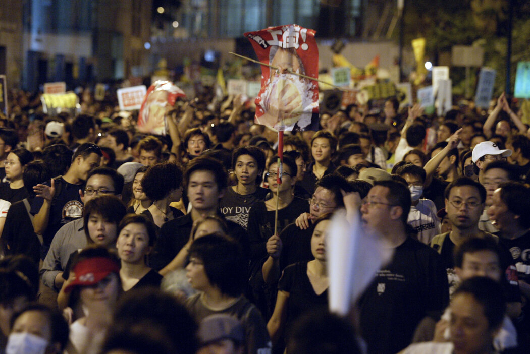 2003年7月1日的一场示威中,一名抗议者举着《壹周刊》封面海报,画面是一只奶油派砸在时任香港特首董建华的脸上。