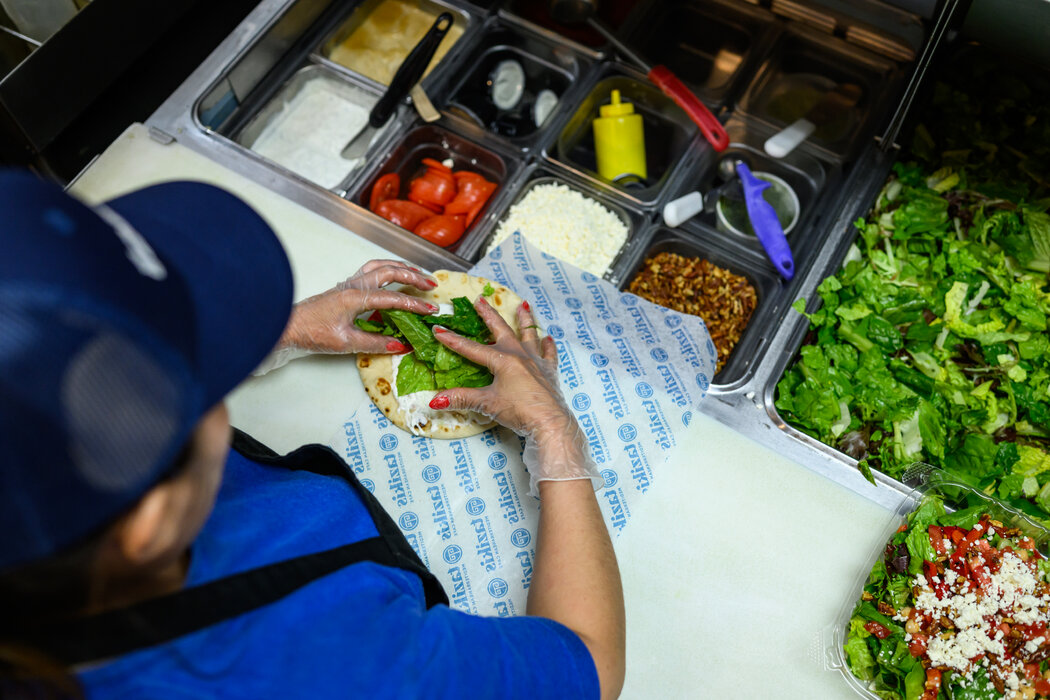 一名塔兹基斯员工正在制作鸡肉卷。辛普森指出,虽然担心移民政策对企业的影响,但“更大的问题在于我们正玷污美国的品牌形象”。